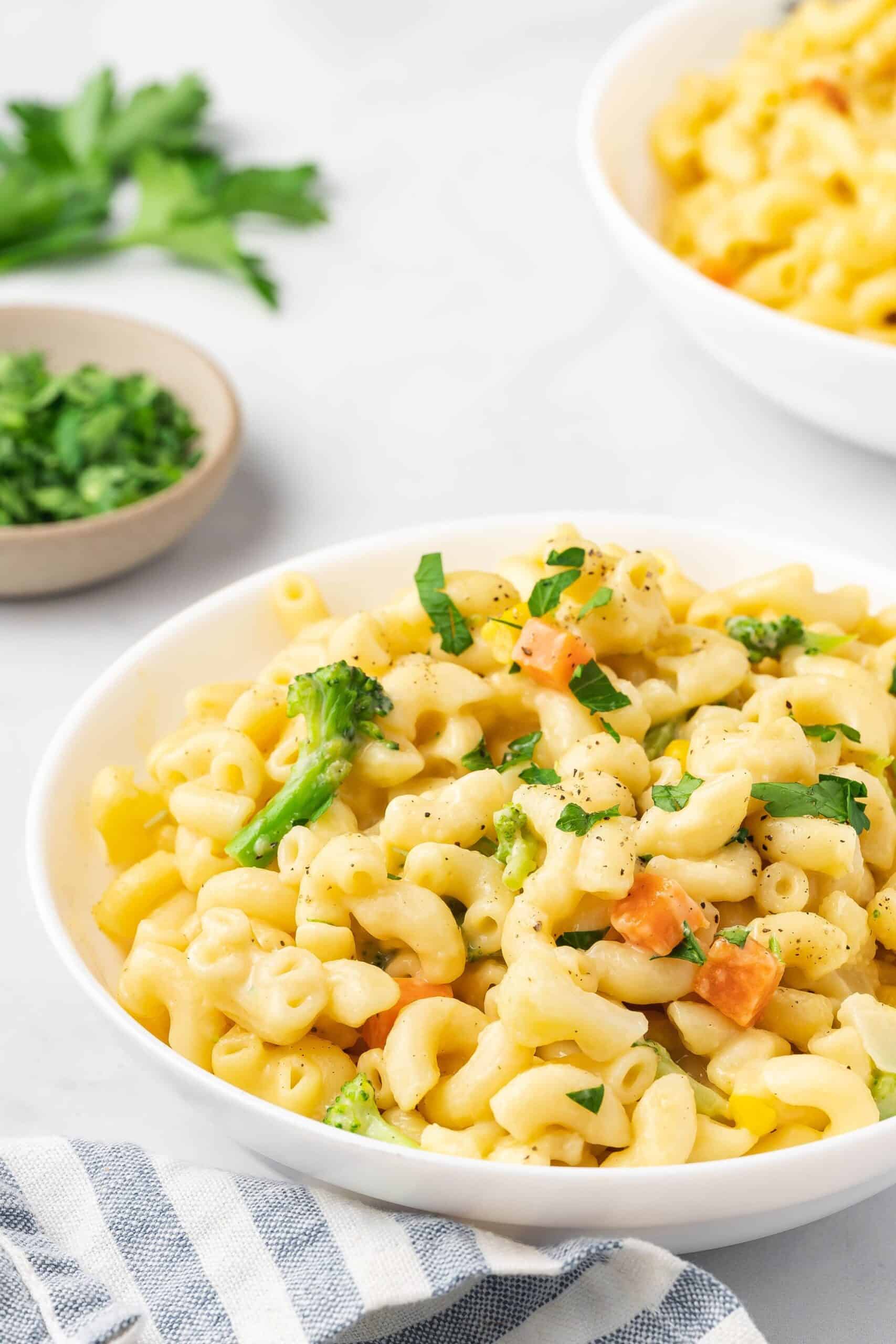 Close-up of a bowl of mac and cheese with melted cheese and broccoli