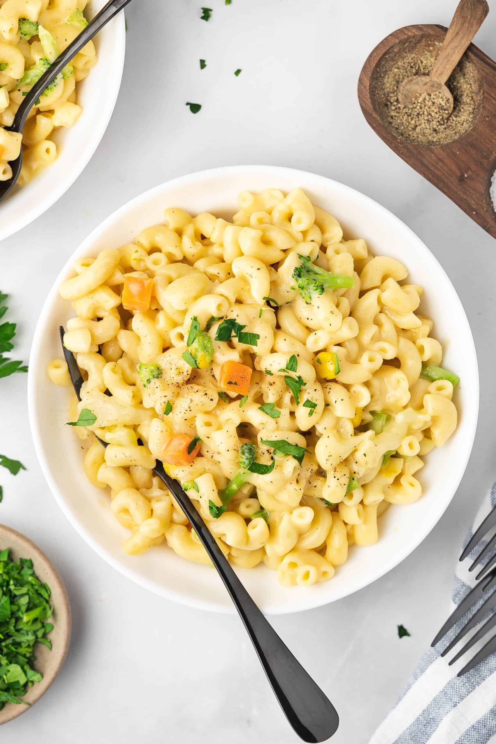 Mac and cheese in a bowl with a sprinkle of fresh parsley on top