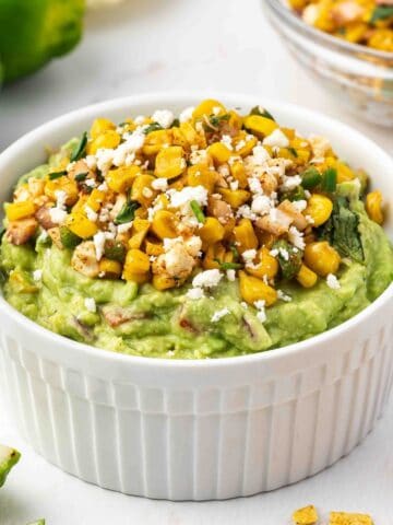 Mexican street corn guacamole served with crispy tortilla chips and fresh cilantro.