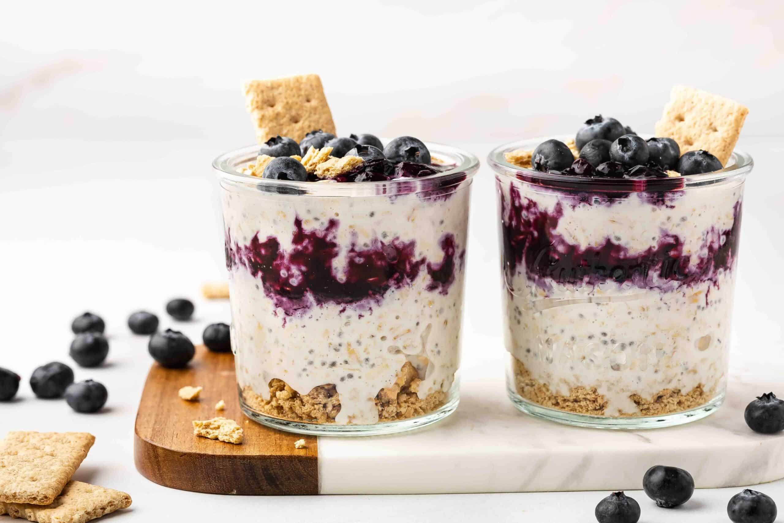 Blueberry Cheesecake Overnight Oats in a glass cup with blueberries on top