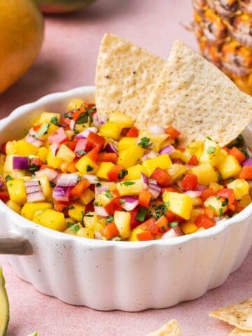 Mango Pineapple Habanero Salsa in a bowl with a lime wedge on the side.