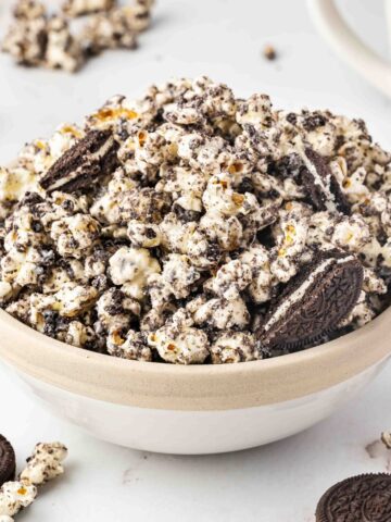 Bowl of cookies and cream popcorn surrounded by crushed Oreos