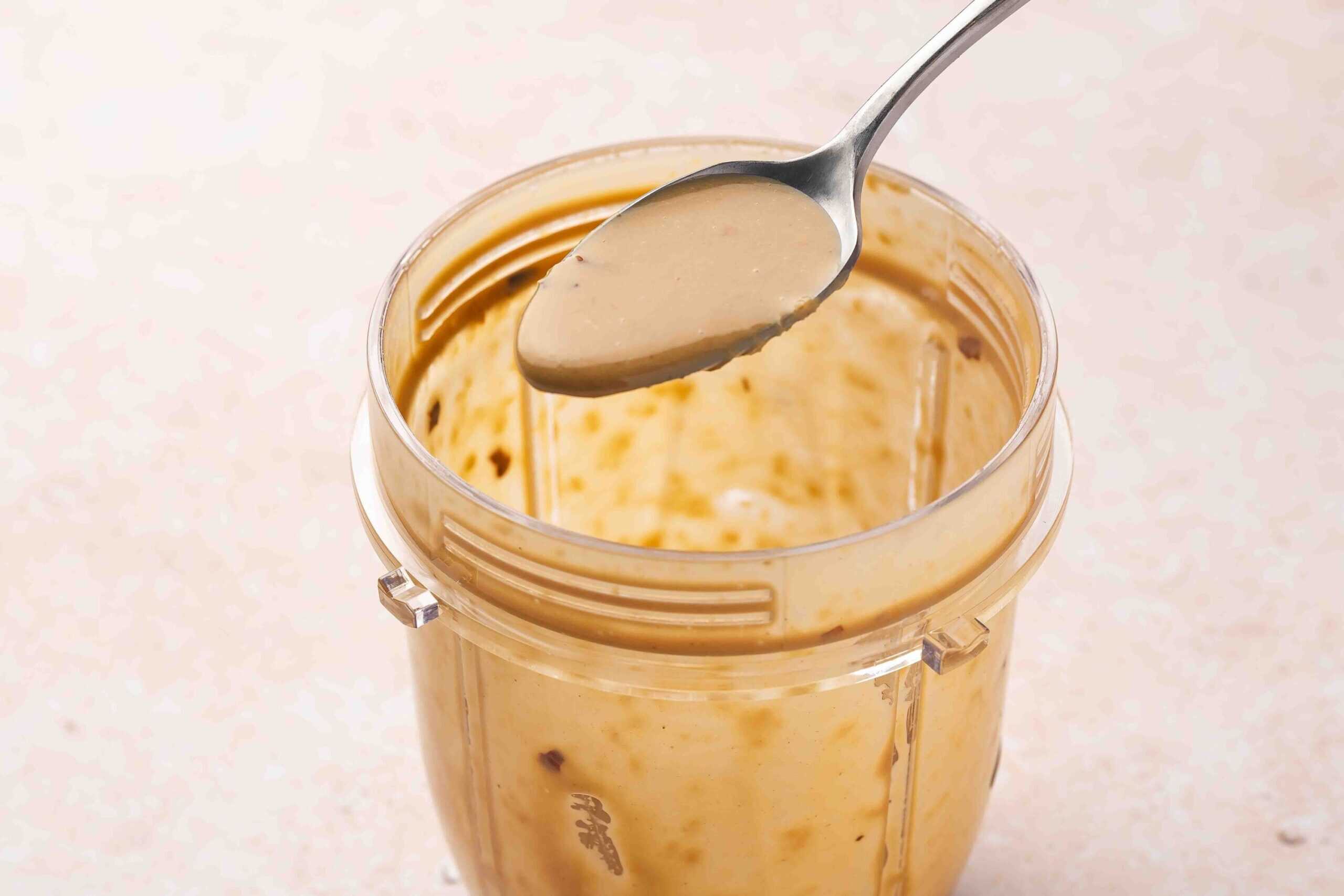 Blending creamy tahini soy ginger dressing in a blender