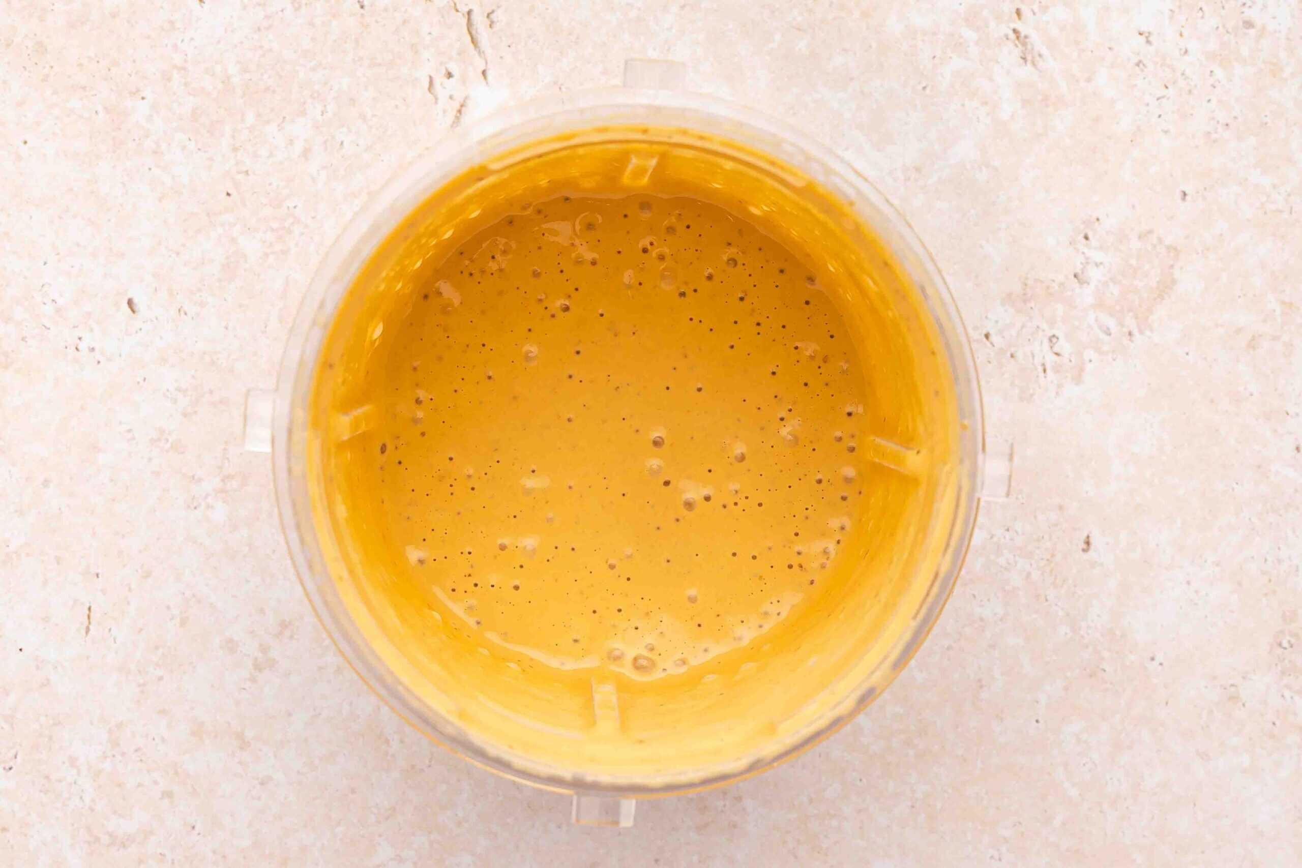 Blending ingredients in a blender until smooth and creamy, then transferring the homemade chipotle sauce into a serving bowl