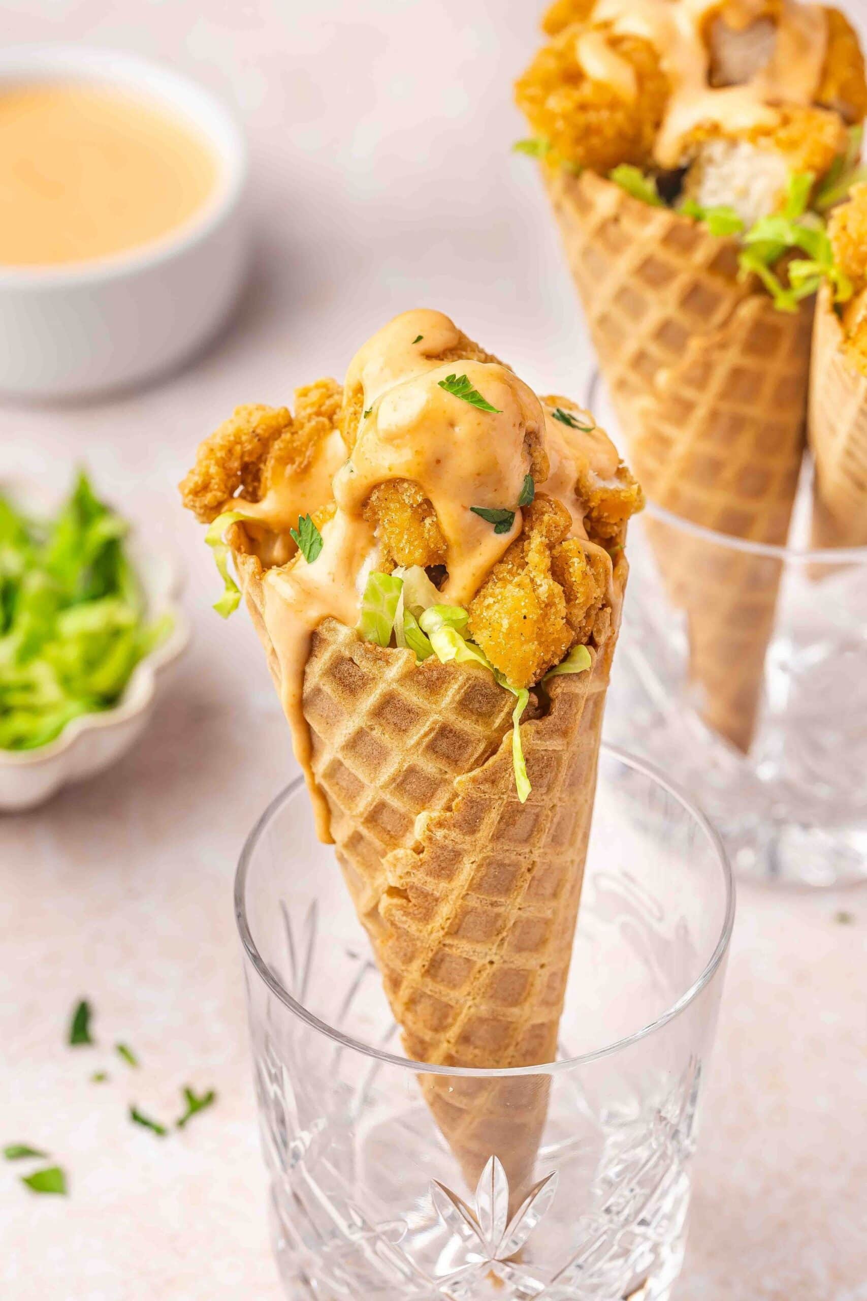 Waffle cones filled with crispy chicken, lettuce, and creamy sriracha