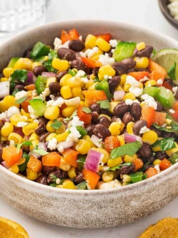 Black bean and corn dip in a ceramic bowl topped with feta