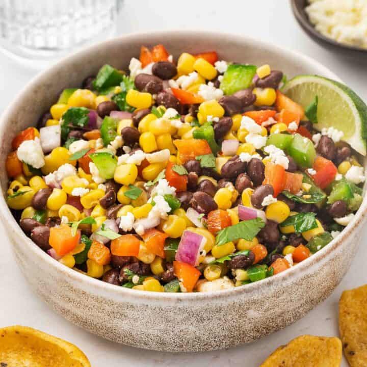 Black bean and corn dip in a ceramic bowl topped with feta