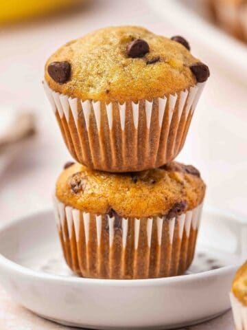 Close-up of a stack of golden banana mini muffins on a white platter