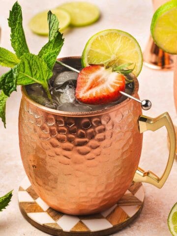 Refreshing Strawberry Moscow Mule cocktail in copper mug with fresh mint and lime garnish.