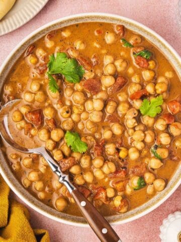 A creamy 5-ingredient chickpea curry served in a white bowl, garnished with fresh cilantro and ready to enjoy with rice or naan.