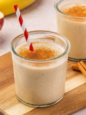 Single glass of creamy apple banana smoothie ready to drink.