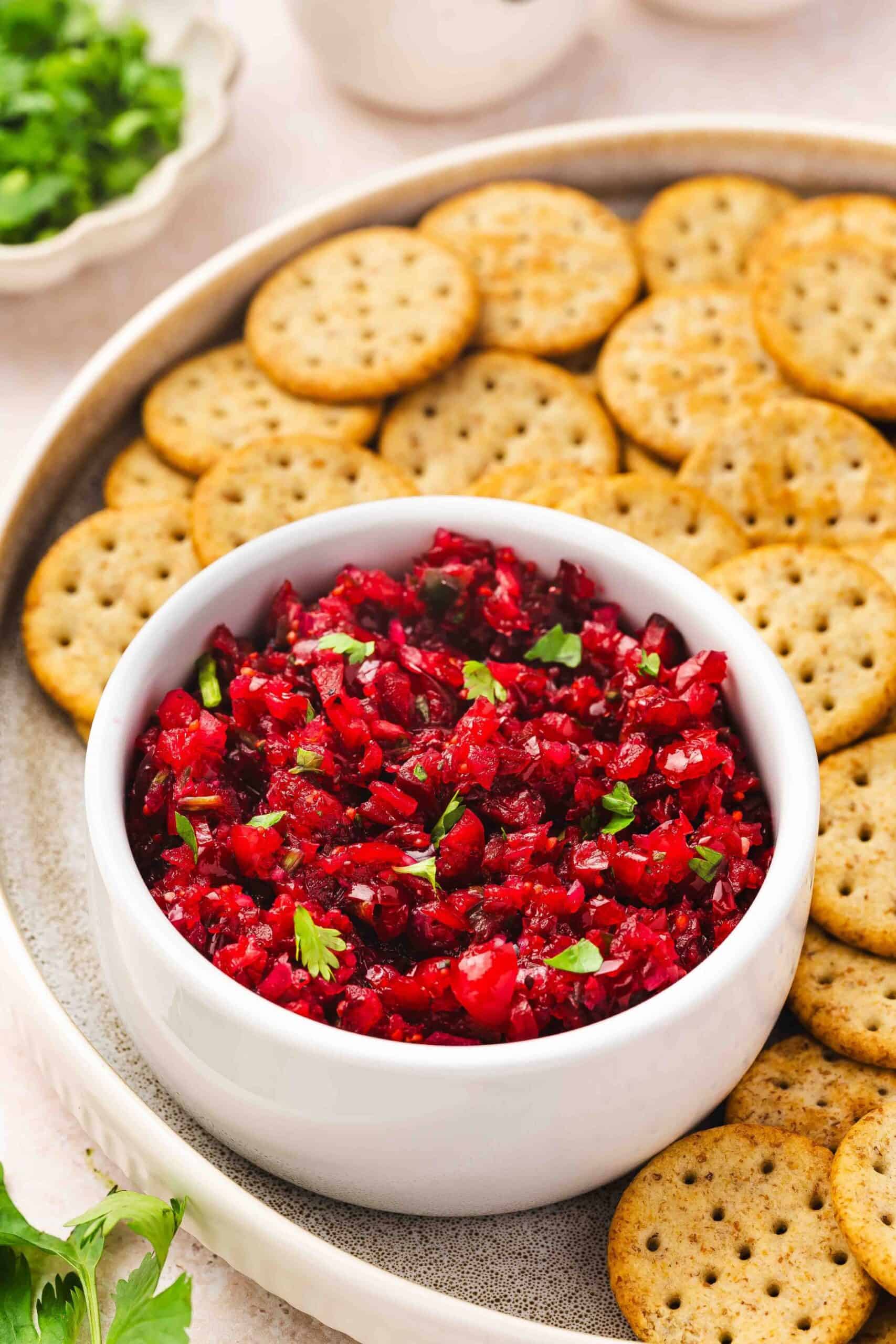 Spicy and sweet cranberry jalapeño salsa in small white bowl for holiday appetizer