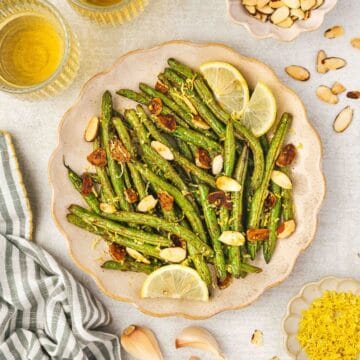 Bright roasted green beans with lemon juice and toasted almonds on top.