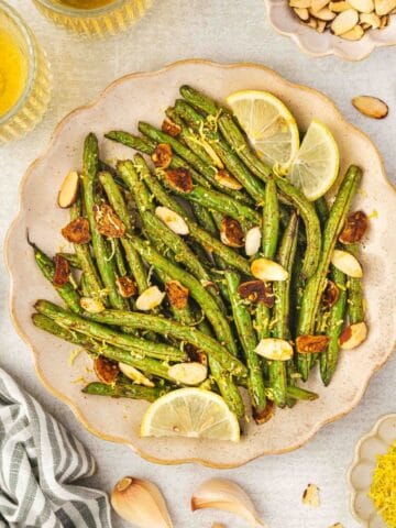 Bright roasted green beans with lemon juice and toasted almonds on top.