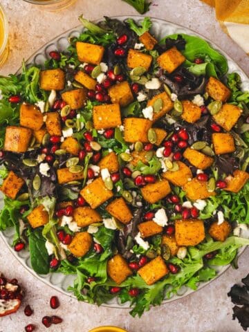 Golden roasted butternut squash cubes with crumbled feta and pumpkin seeds, ready to serve