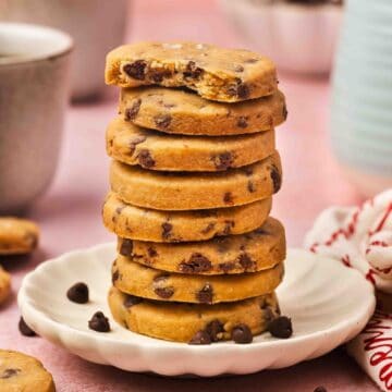 Stacked espresso chocolate chip shortbread cookies on a rustic board with a cozy winter vibe