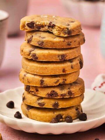 Stacked espresso chocolate chip shortbread cookies on a rustic board with a cozy winter vibe