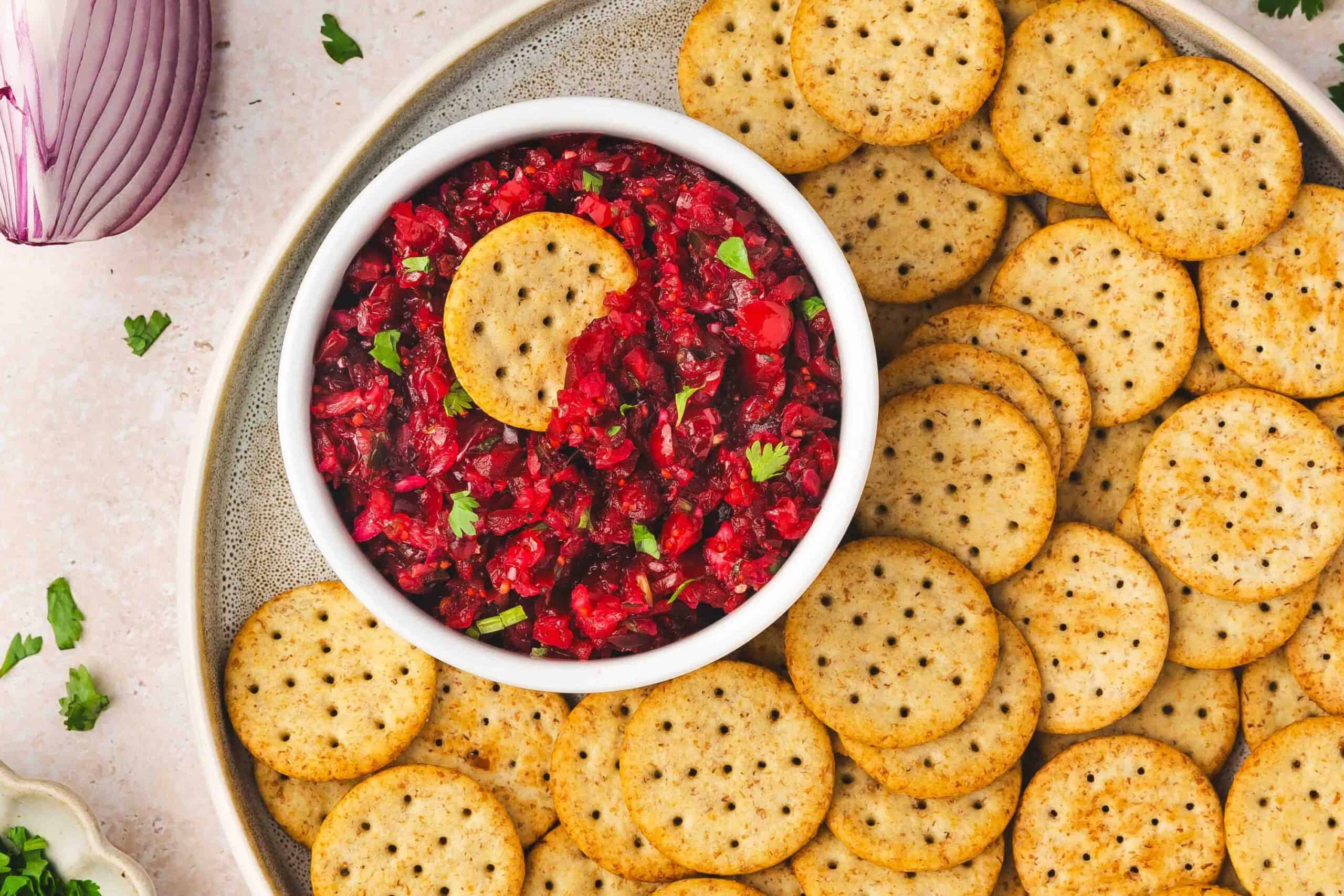 Top view of cranberry jalapeño salsa with cilantro and lime in white bowl