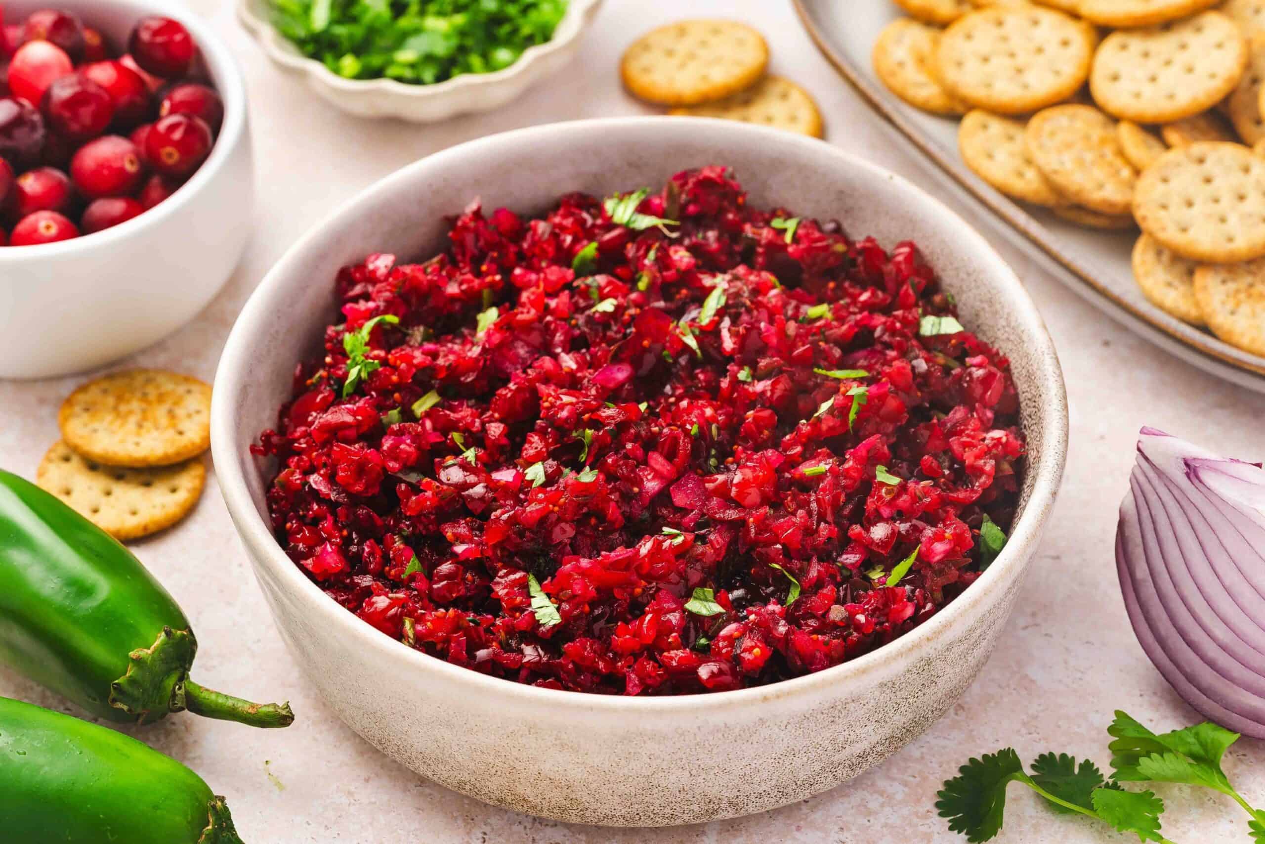 Cranberry jalapeño salsa with red and green garnish in white serving bowl