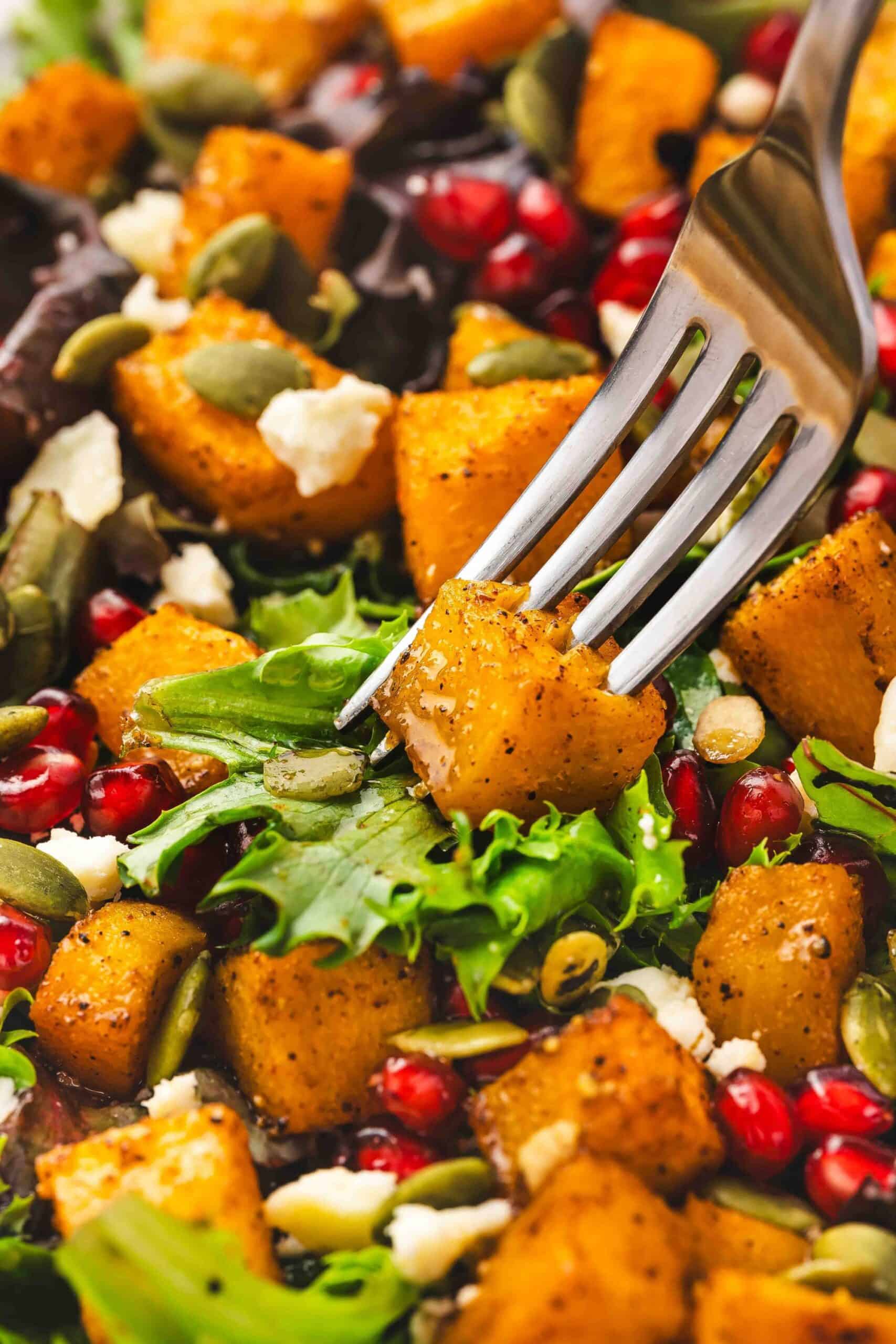 Close-up of roasted squash, feta, and pumpkin seeds tossed in a salad