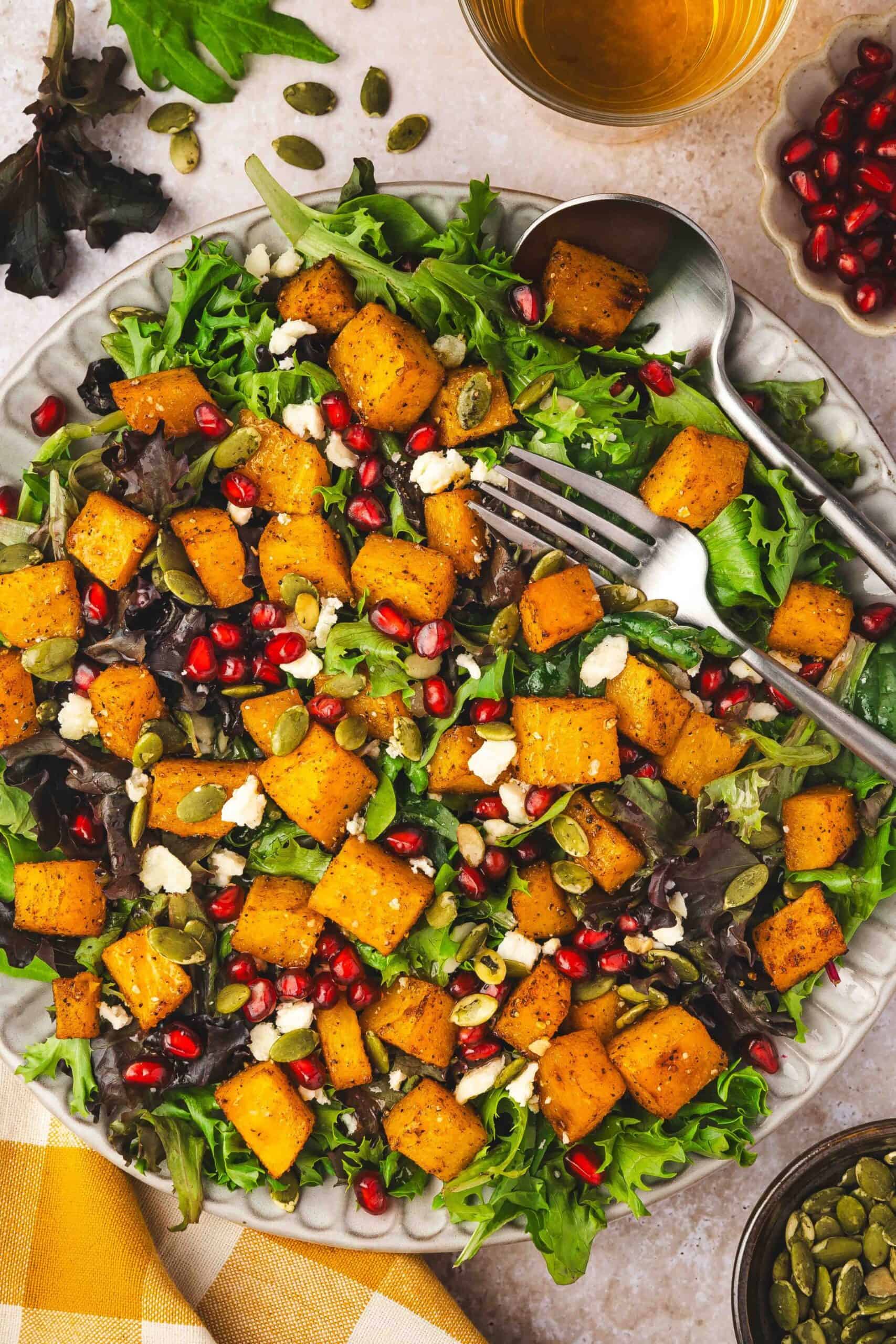 Bowl of roasted butternut squash feta salad with a drizzle of dressing