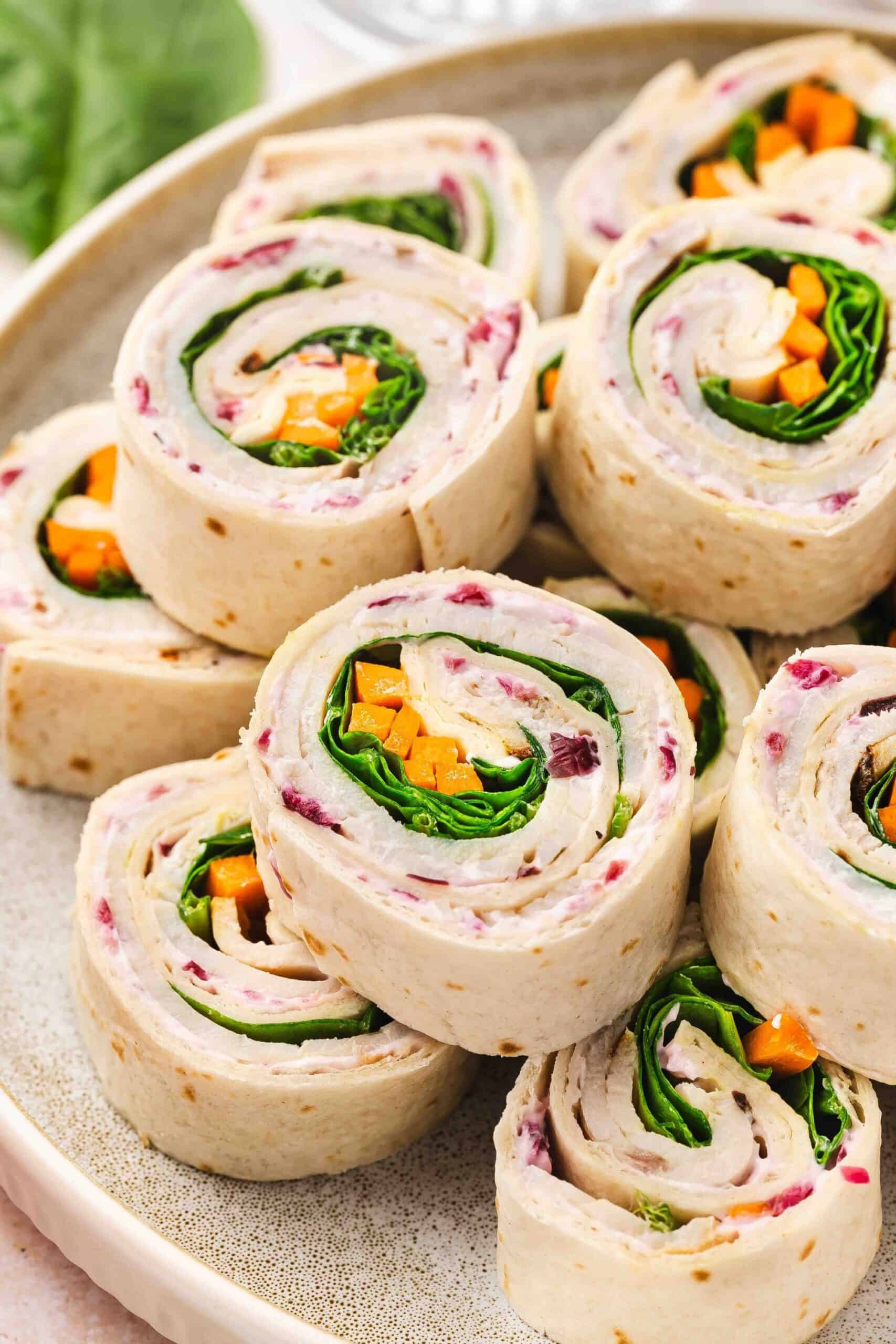 Healthy turkey pinwheels with cranberry cream cheese, spinach, and julienned carrots.