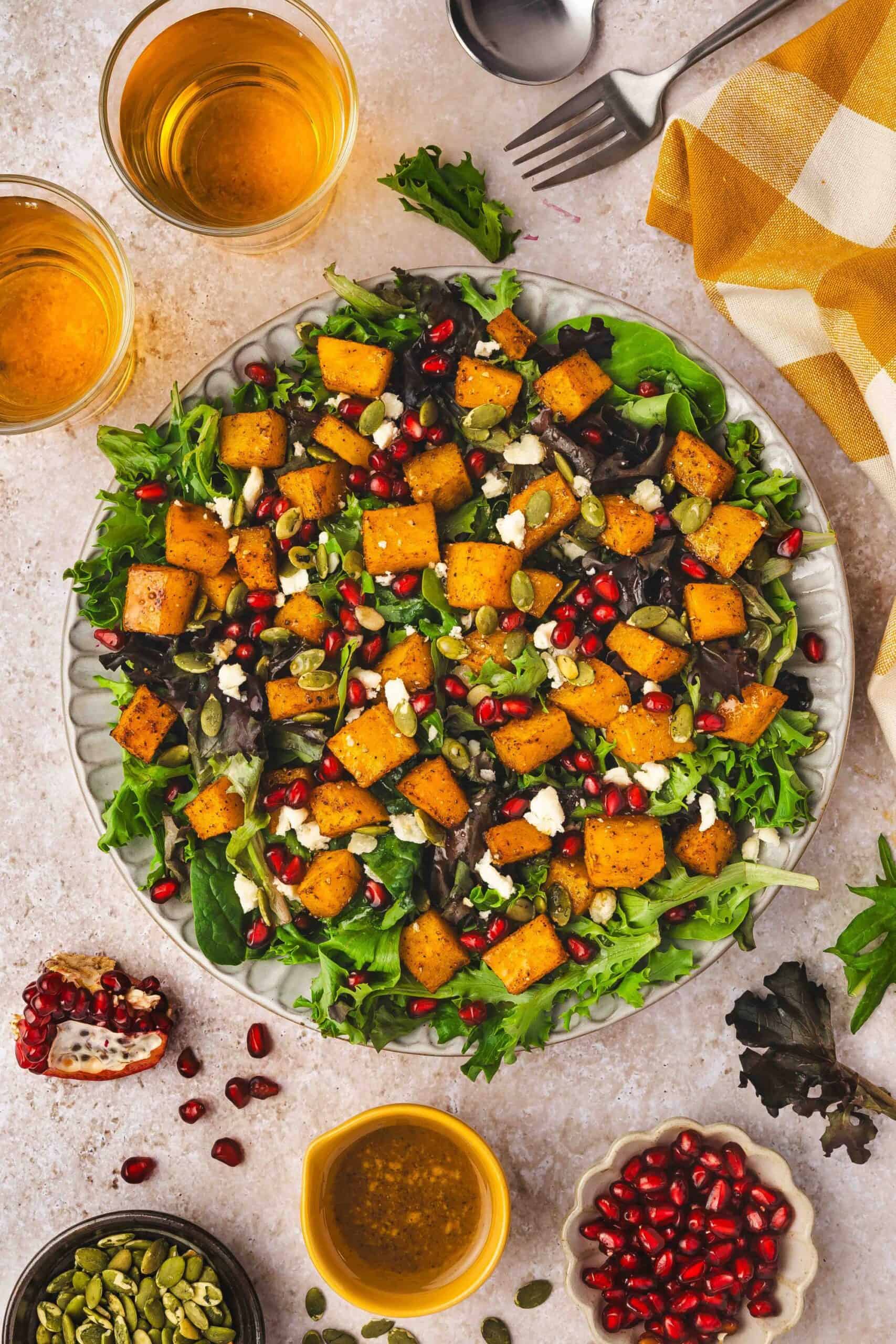 Colorful holiday side salad with tender roasted squash, feta, and a drizzle of dressing