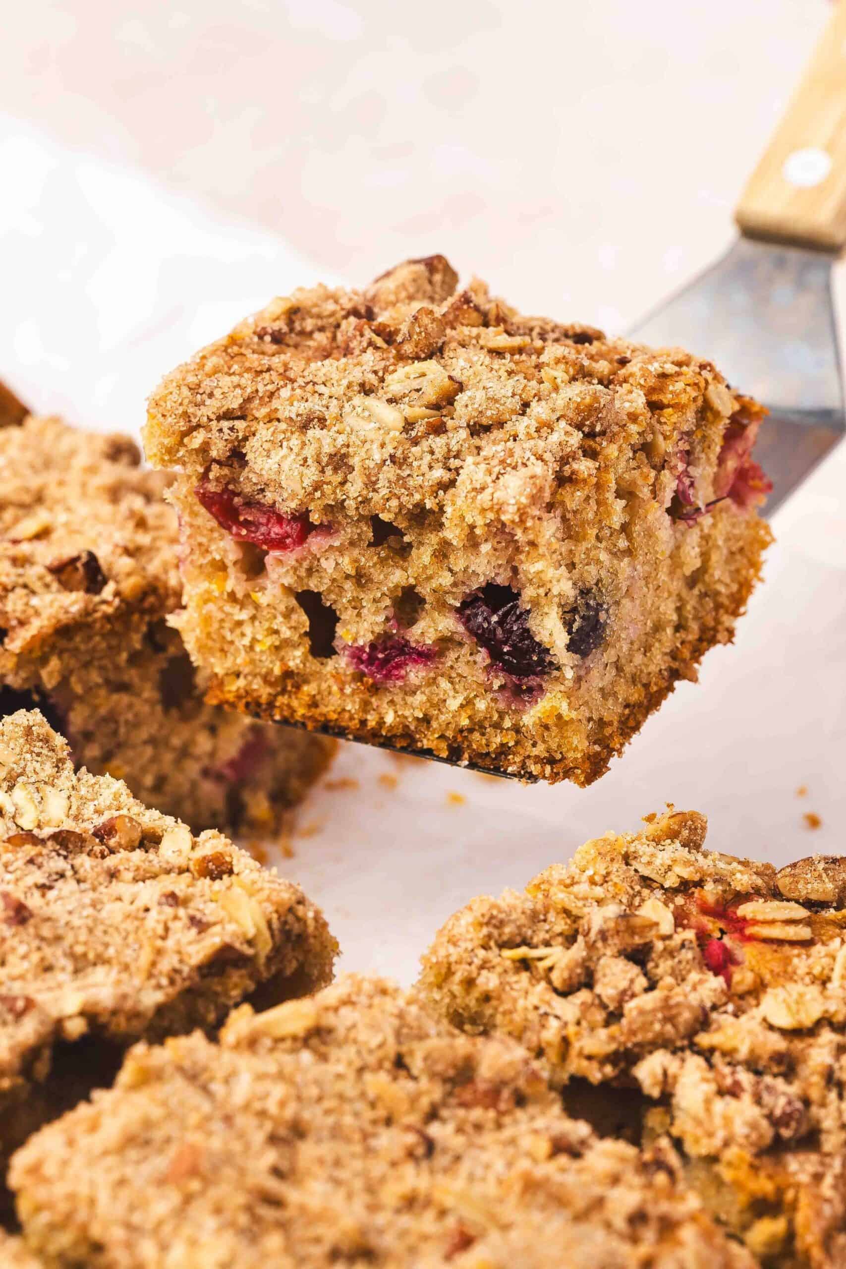 Moist cranberry orange coffee cake slice on a plate drizzled with yogurt glaze