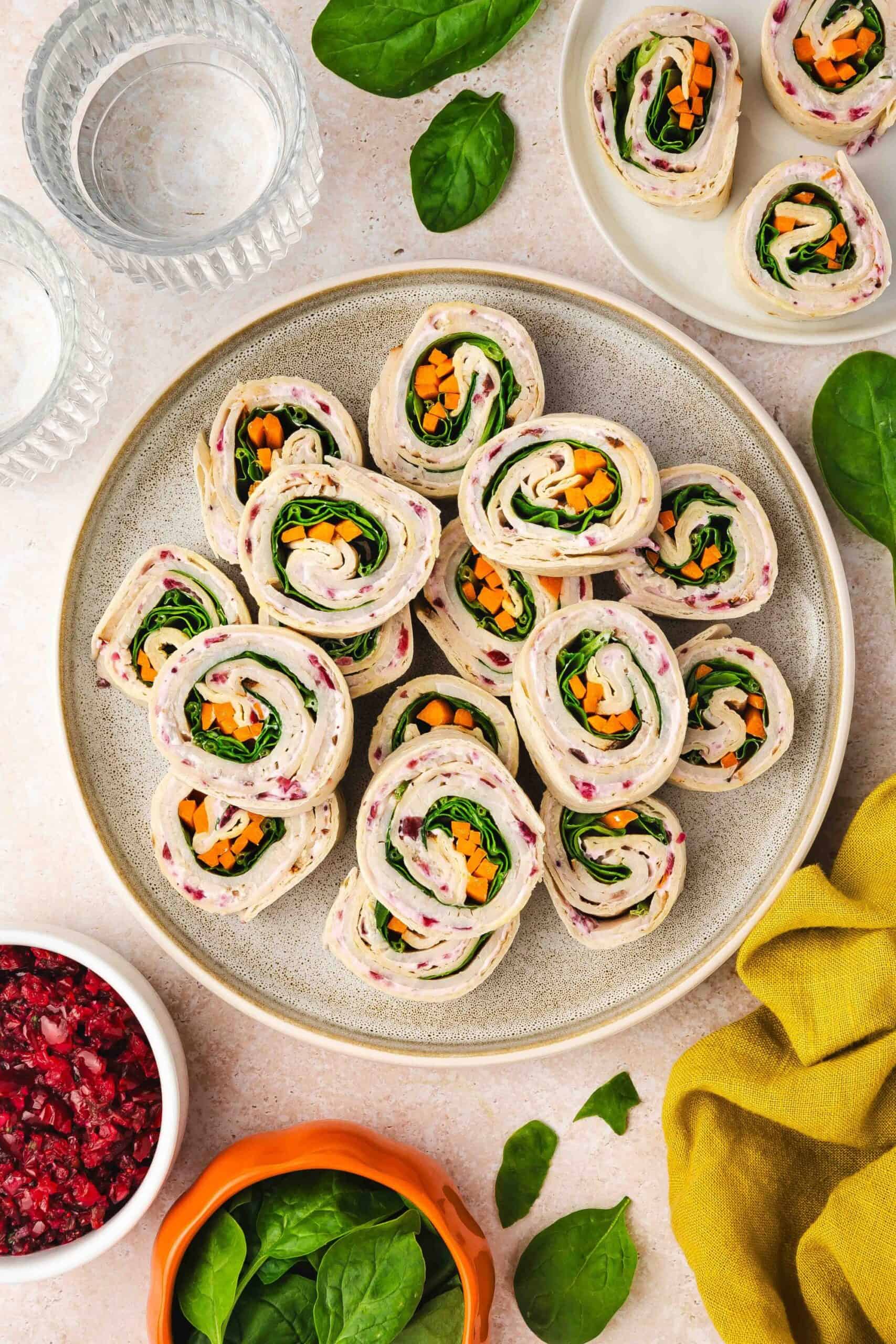Close-up of sliced turkey and veggie roll-ups with creamy cranberry cheese spread.