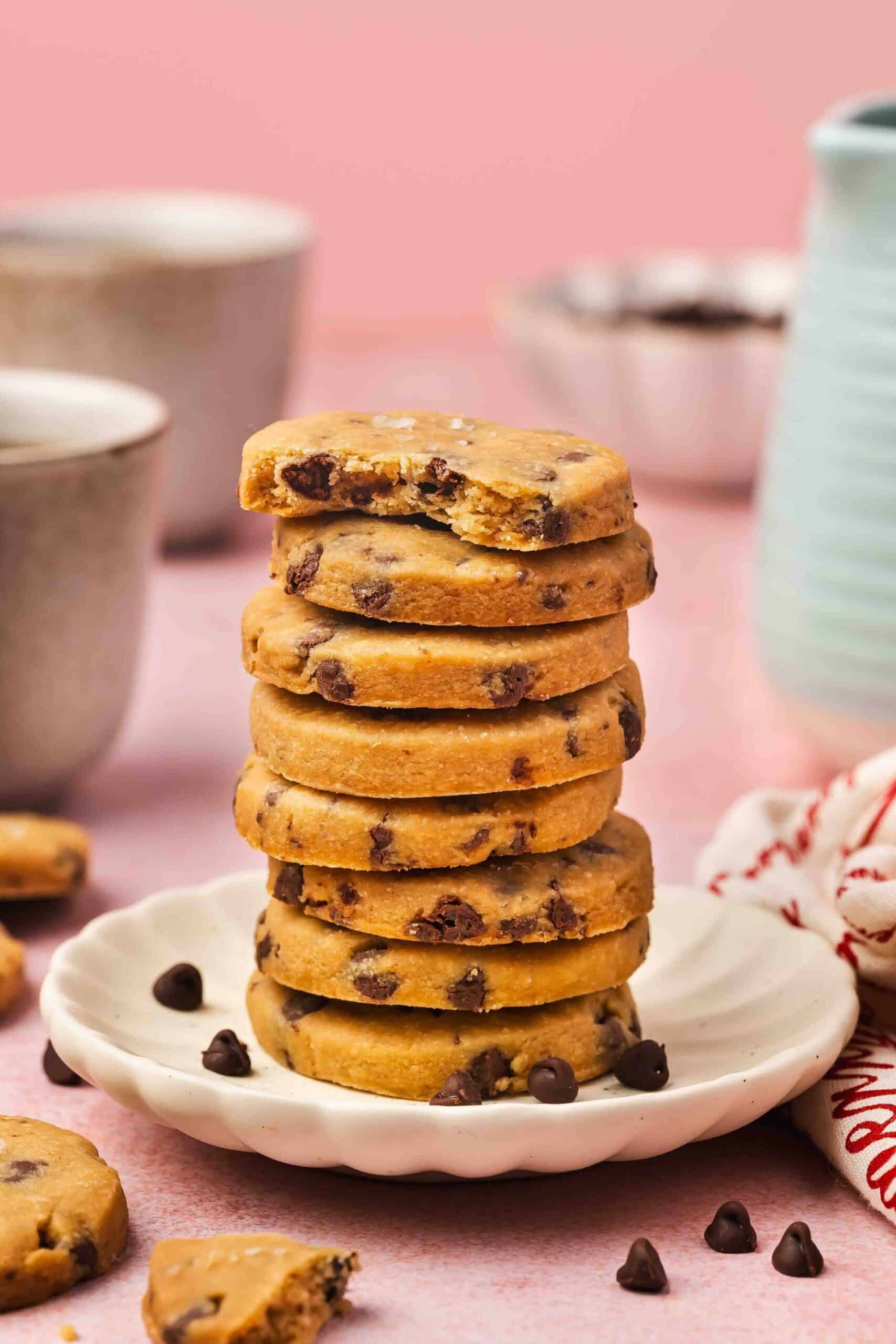 Stack of buttery espresso chocolate chip shortbread cookies on a plate, showing chocolate chunks and golden edges