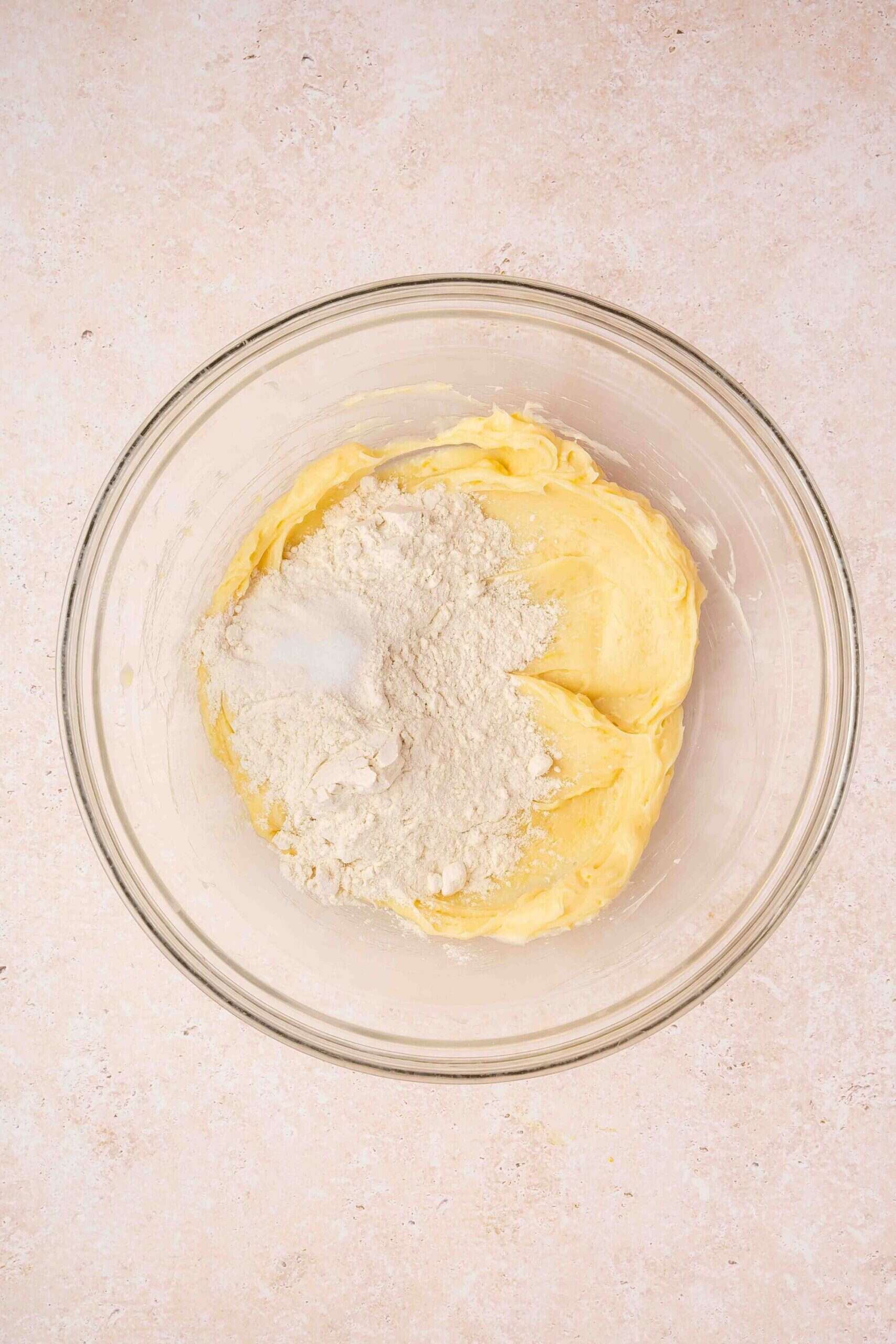 Adding all-purpose flour and salt to the wet mixture for thumbprint cookie dough.