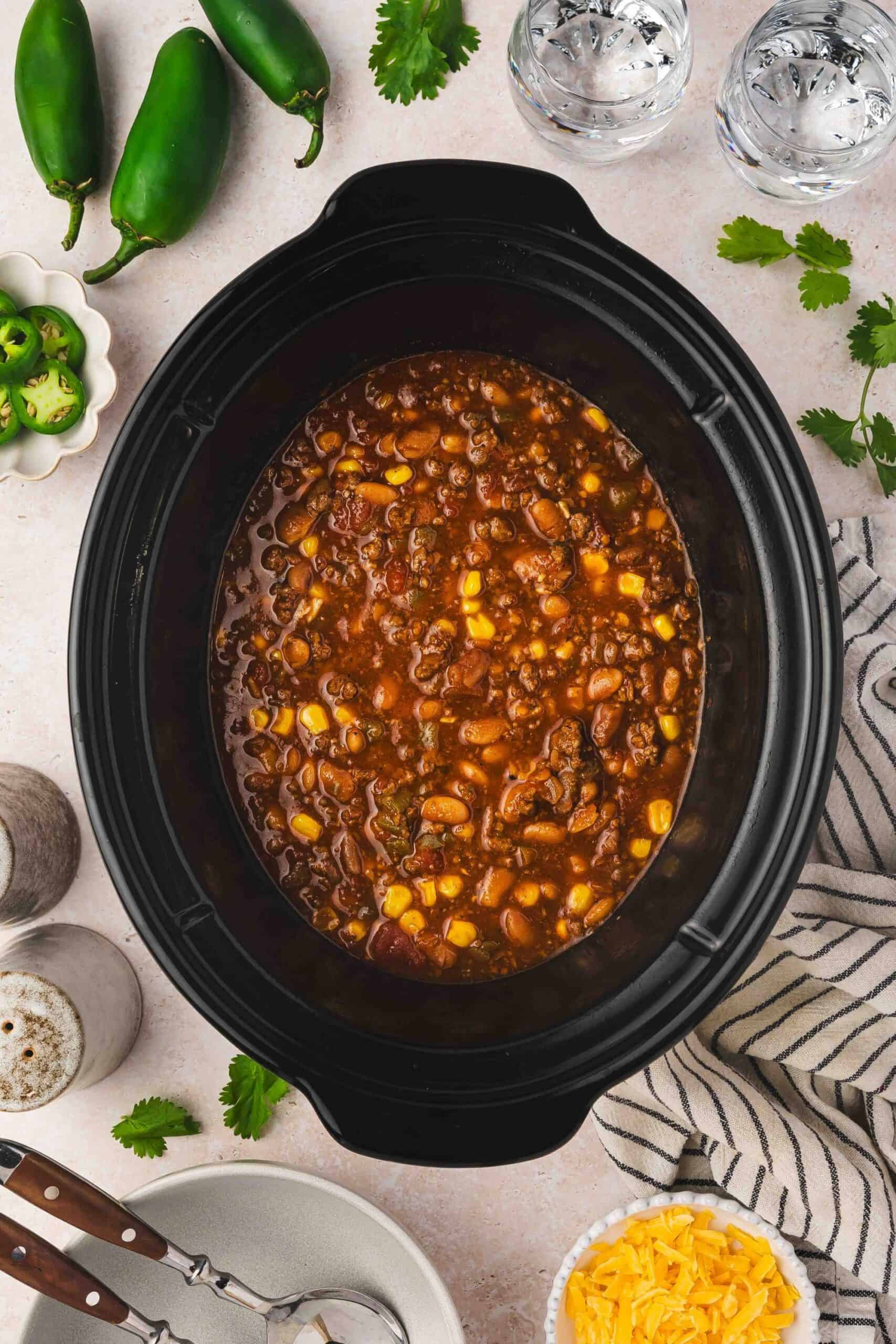 Easy homemade chili with ground beef, pinto beans, and corn simmering in a crockpot.