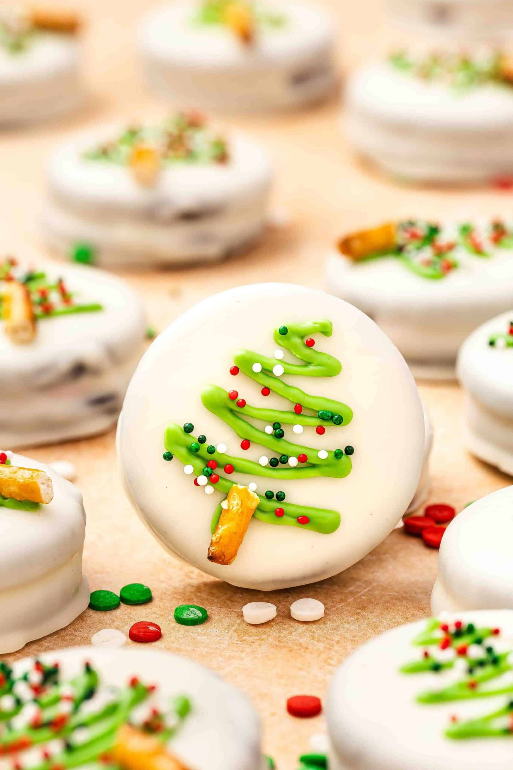 Macro shot of festive white chocolate covered Oreo showing pretzel trunk and colorful sprinkles.