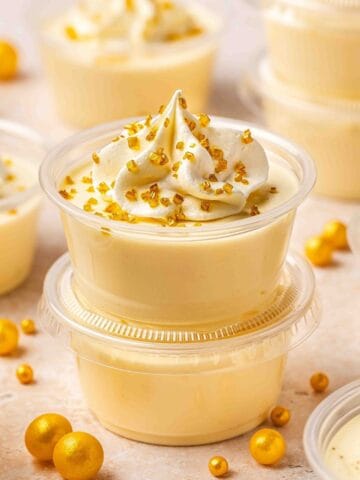 Festive close-up of pudding shots with golden sugar-topped whipped cream and smooth, creamy RumChata base.