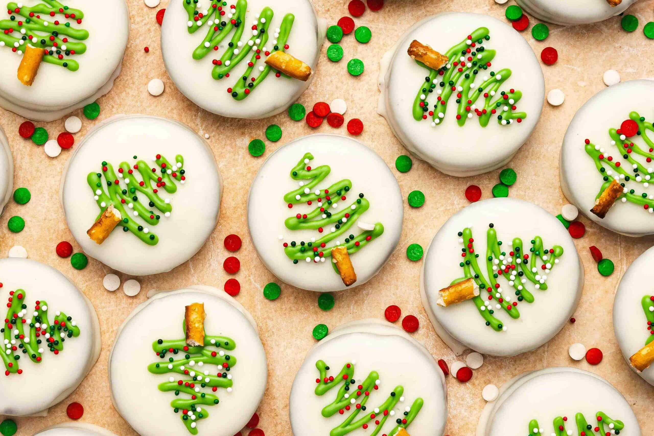 White chocolate covered Oreos with festive green drizzle and candy decorations.