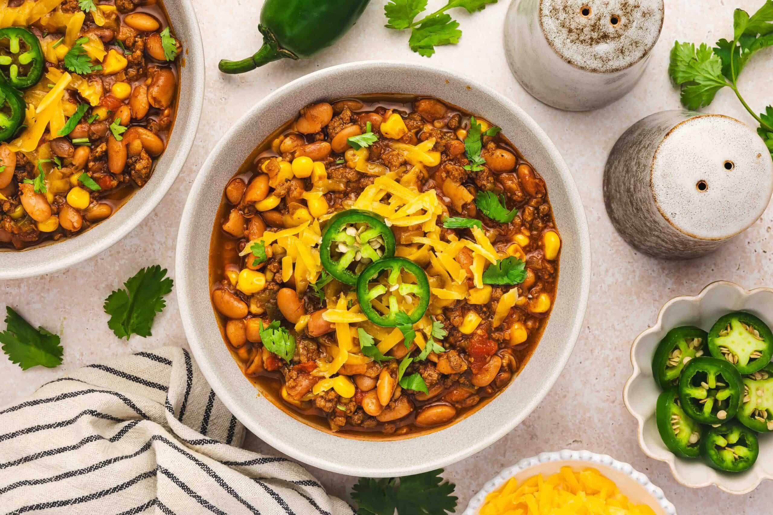 Southwest-style chili with ground beef, beans, corn, and spices served in a bowl with fresh toppings.